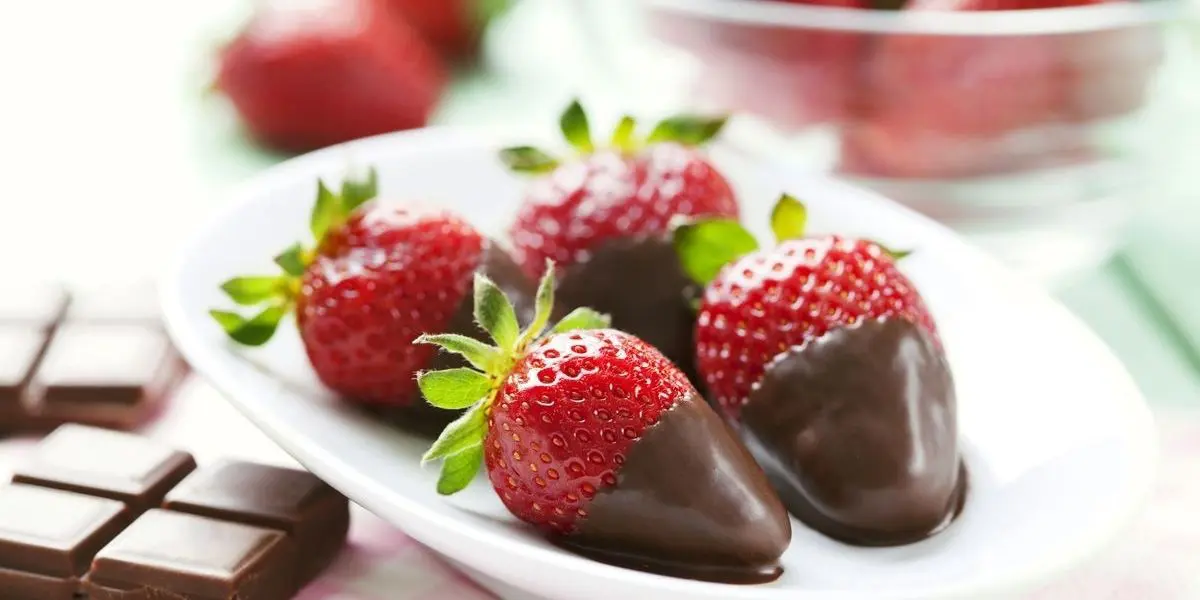 Fragole ricoperte di cioccolato su piattino