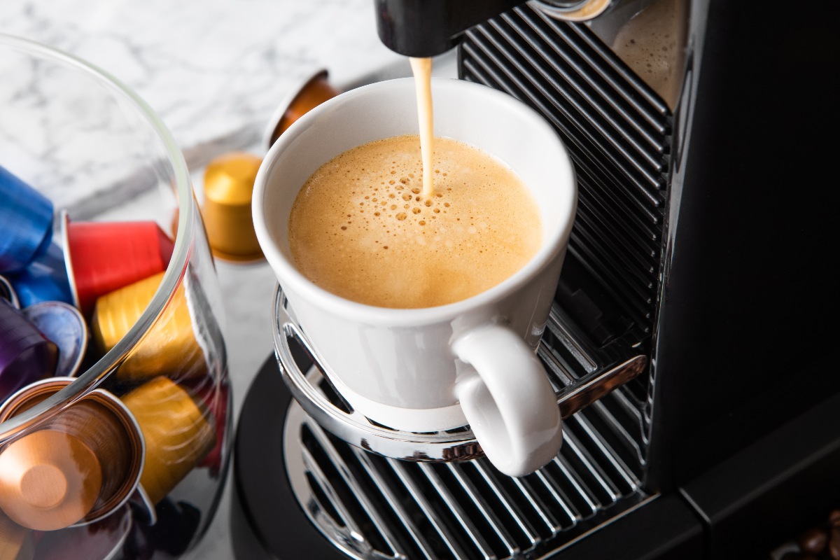 Macchinetta del caffè con cialde e tazzina pronta