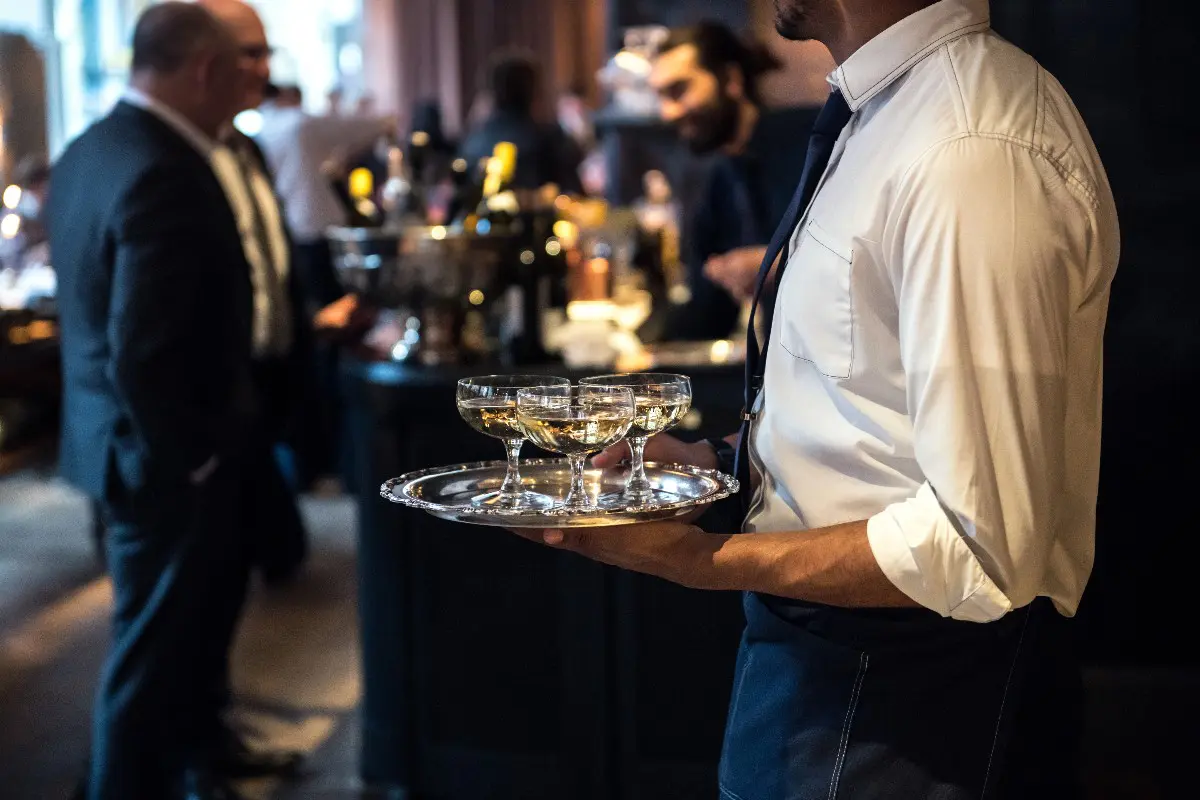 Cameriere in servizio con bicchieri al ristorante