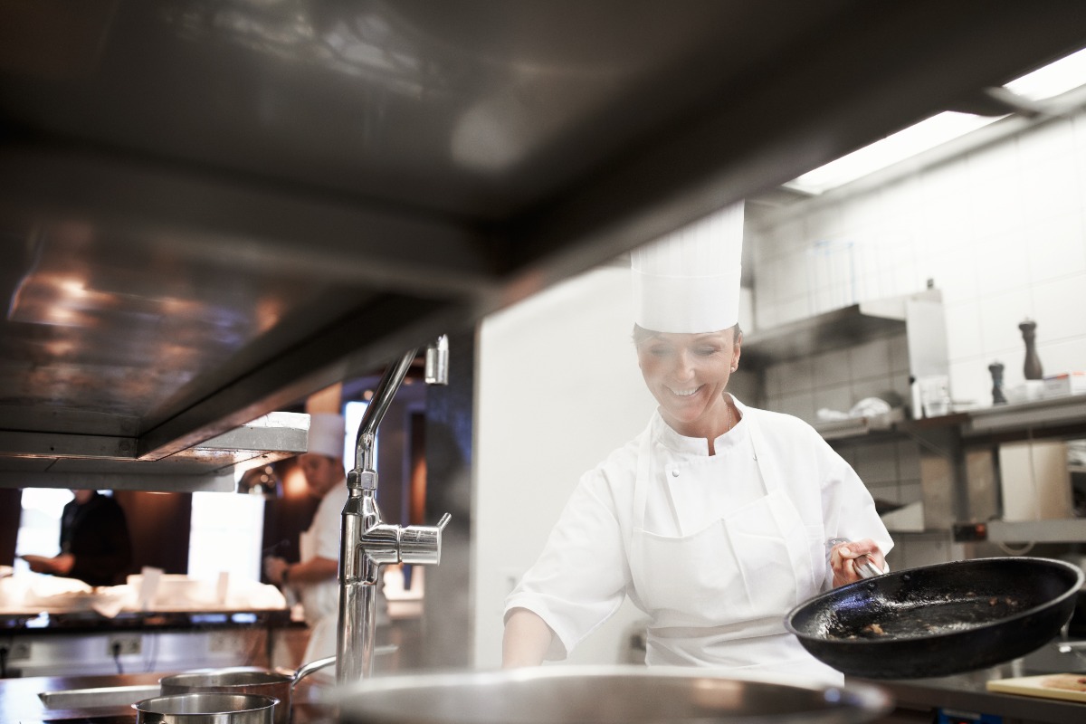 Chef donna al lavoro nella cucina del ristorante.