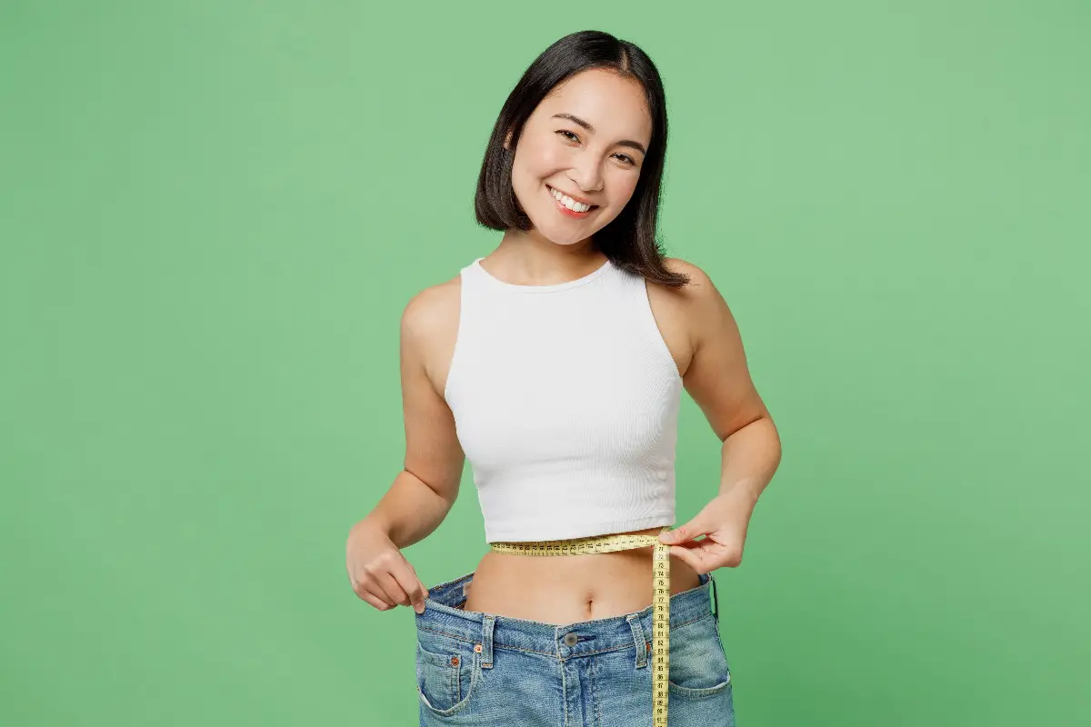 Controllo della dieta: ragazza con metro e jeans
