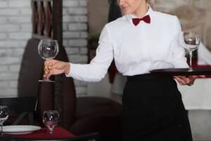 Cameriera serve calici in ristorante elegante